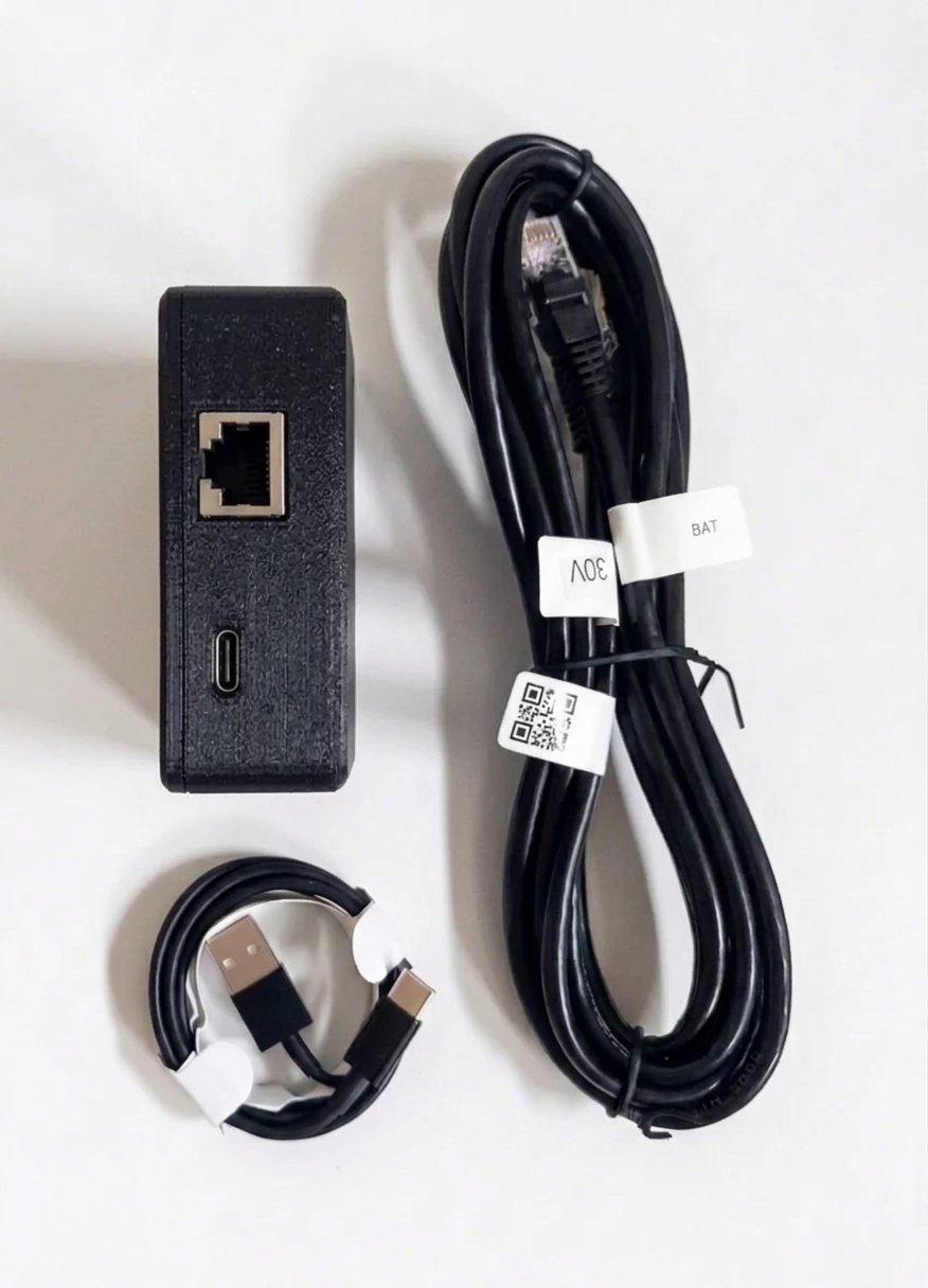 Pylon-Monitor V3 Premium en su caja negra mate, puertos RJ45 y USB-C, con el cable de consola RJ45 y el cable USB-C incluidos